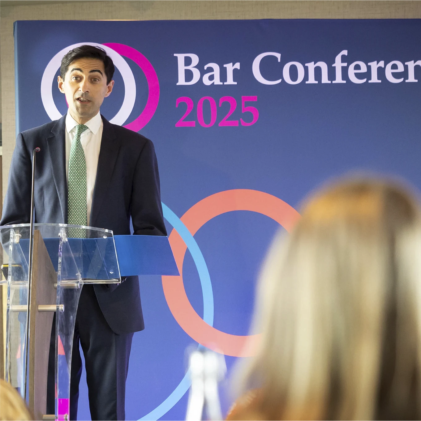 Photography of a keynote speaker with large printed banner graphic.