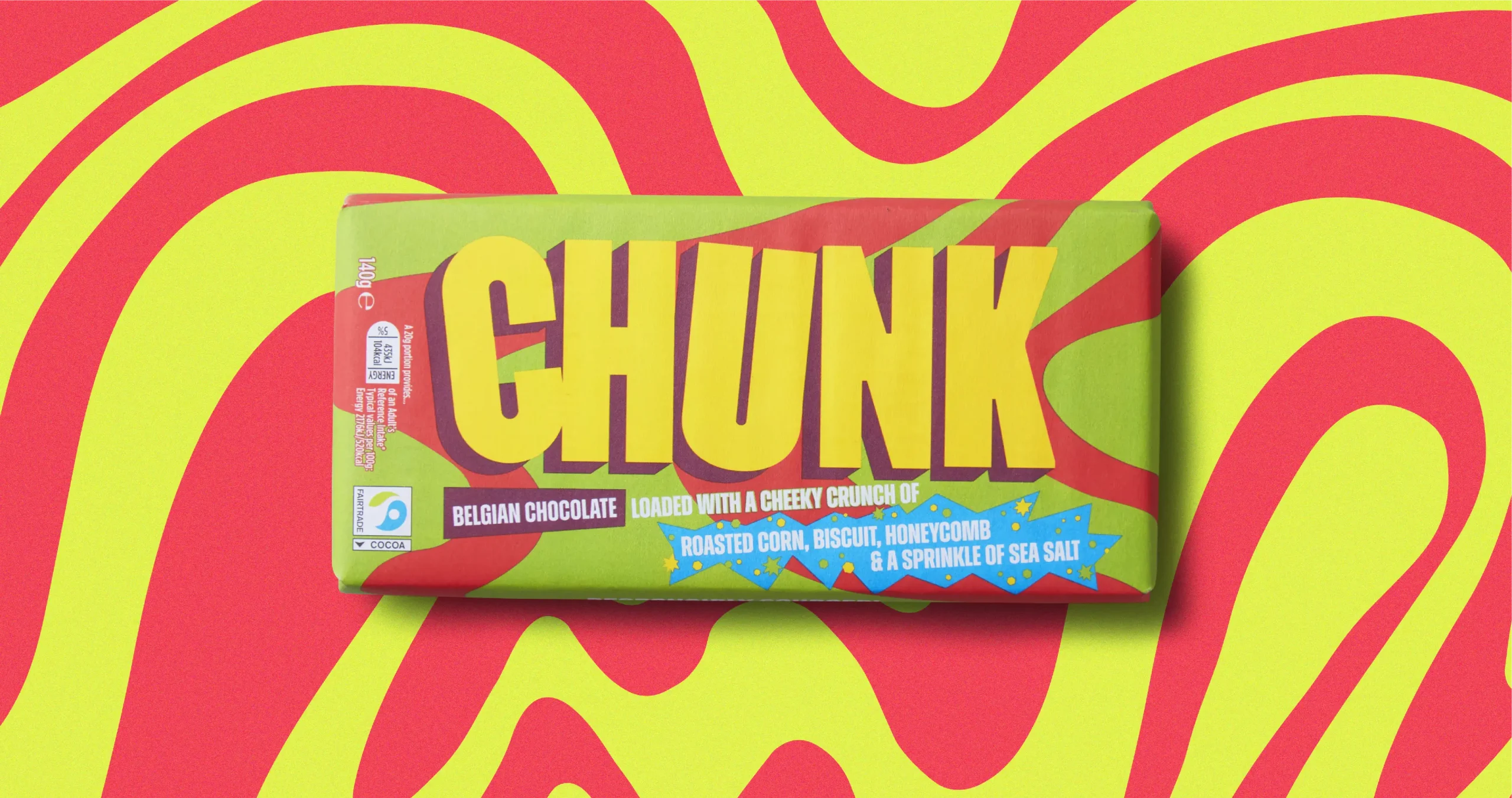 Roasted Corn, Biscuit, Honeycomb & Sea Salt Chunk chocolate bar photographed on top of a wavy marbled green and red background.