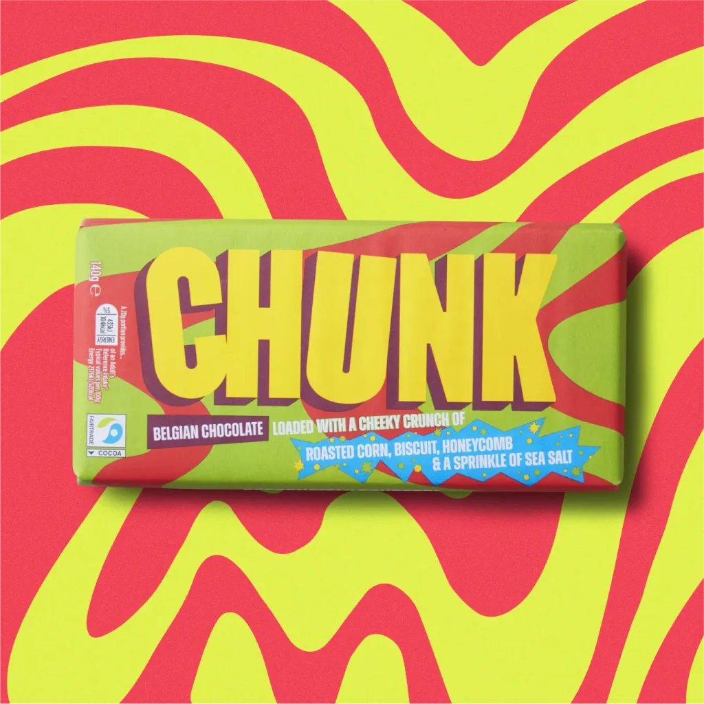 Roasted Corn, Biscuit, Honeycomb & Sea Salt Chunk chocolate bar photographed on top of a wavy marbled green and red background.