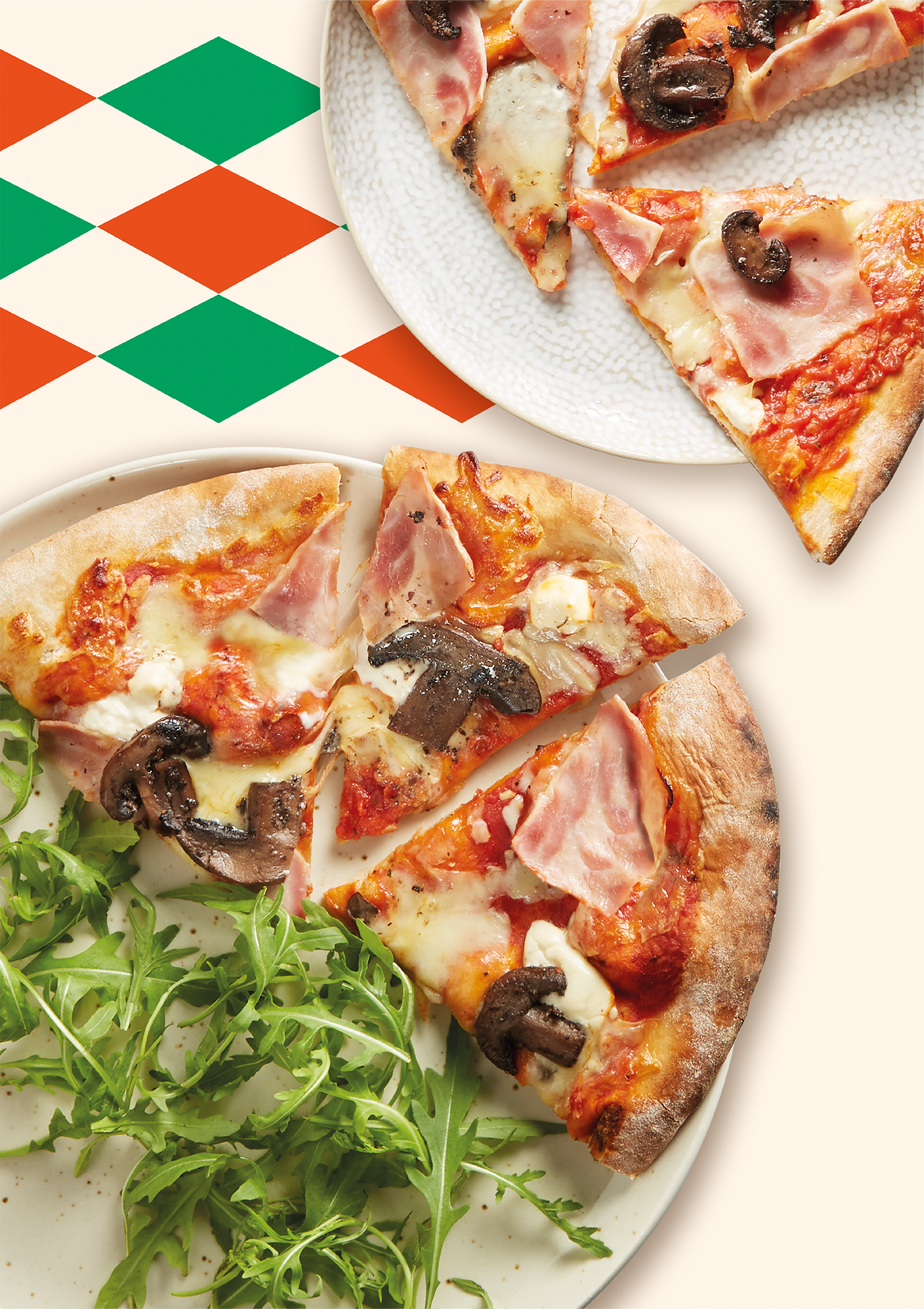 Overhead photography of a Ham, Mushroom and Mascarpone pizza. Shot on white plates with rocket, against an orange and green harlequin background pattern.