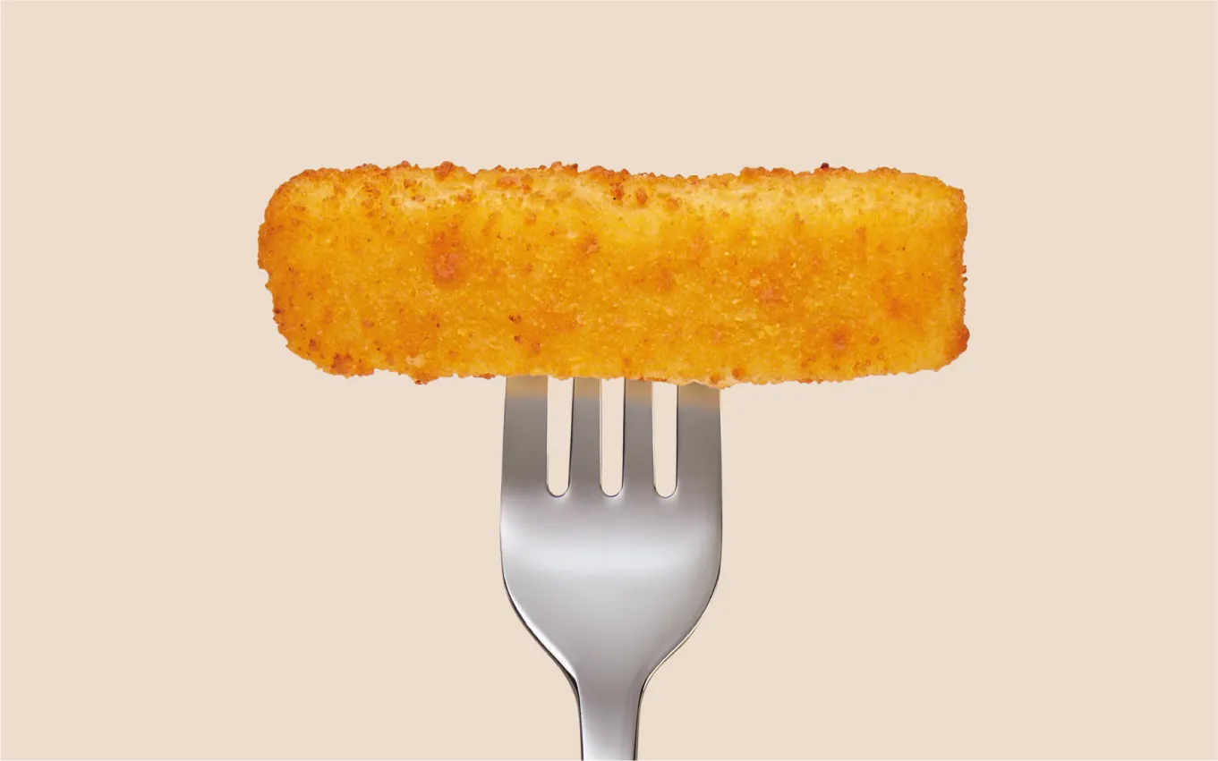 Photography of a singular golden fish finger on a fork.