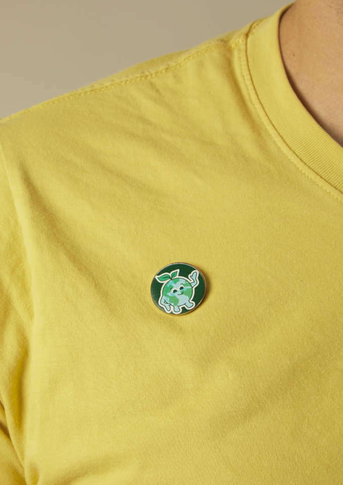 Model wearing a yellow shirt, with a Globey pin badge.